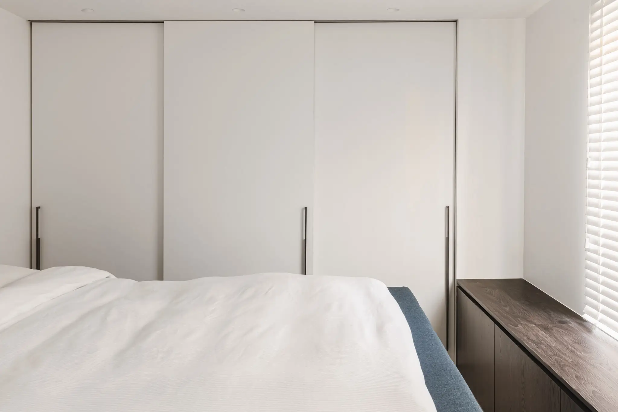 Slaapkamer met een witte kastenwand